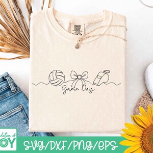 May include: Cream-colored t-shirt with a minimalist line art design featuring a volleyball, bow, and whistle, with the words "Game Day" in script. The shirt has a Comfort Colors tag and a delicate necklace. The bottom of the image has the text "Foundation of JOY" and "SVG/DXF/PNG/EPS".