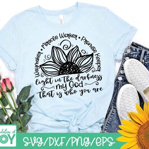 Pode incluir: Uma camiseta azul claro com um gr&aacute;fico de girassol preto e o texto "Waymaker Miracle Worker Promise Keeper light in the darkness my God that is who you are".