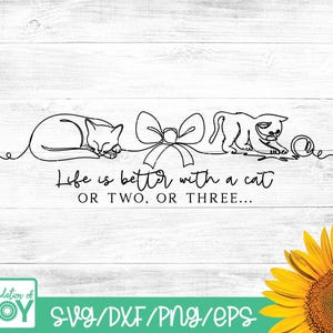 May include: Black line art design featuring two cats, a bow, and a ball of yarn on a white wooden background. The text "Life is better with a cat OR TWO, OR THREE..." is included. A sunflower is in the bottom right corner.