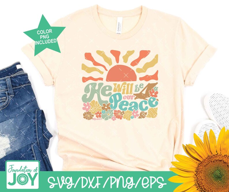 May include: A beige t-shirt with a retro-style graphic design featuring a sun, flowers, and the text "He will be our peace".