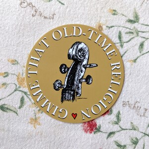 Puede incluir: Una pegatina redonda dorada con el texto "That Old-Time Religion Give" y una ilustración en blanco y negro de un cuello de violín con clavijas.