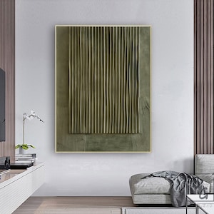 May include: Abstract art print featuring a textured, green and brown design. The print is framed in a thin, gold frame.