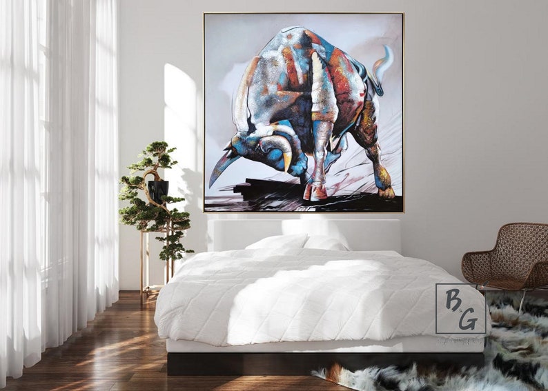 Puede incluir: Una pintura abstracta colorida de un toro cargando hacia adelante. El toro est&aacute; pintado en tonos de azul, rojo, blanco y marr&oacute;n. El fondo es gris claro con toques de rosa y morado.