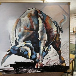 Puede incluir: Una gran pintura abstracta de un toro cargando. El toro est&aacute; pintado en tonos de azul, marr&oacute;n, blanco y dorado. El fondo es gris claro.