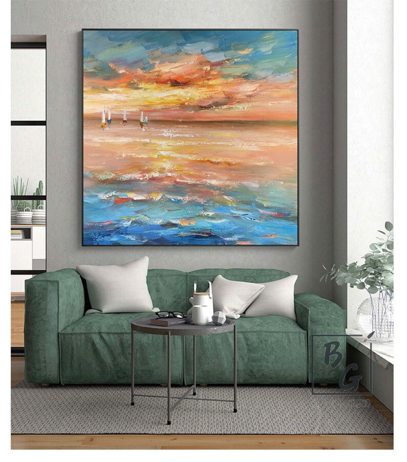 Puede incluir: Una pintura que representa un paisaje mar&iacute;timo con un cielo de puesta de sol y tres veleros en la distancia. El agua es de un azul vibrante y el cielo es una mezcla de naranja, amarillo y rosa.