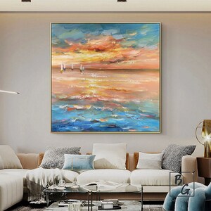 Puede incluir: Pintura abstracta de un paisaje mar&iacute;timo con un cielo de puesta de sol en tonos de naranja, amarillo y azul. La pintura presenta un horizonte con algunos peque&ntilde;os veleros blancos en la distancia.