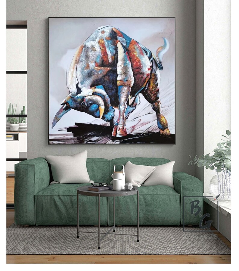 Puede incluir: Una pintura abstracta colorida de un toro cargando. El toro est&aacute; pintado en tonos de azul, rojo, naranja y blanco. El fondo es gris claro con toques de rosa y azul.