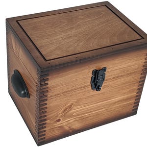 May include: A wooden box with a hinged lid, a black metal handle, and a black metal latch. The box is stained a dark brown color and has a distressed finish.