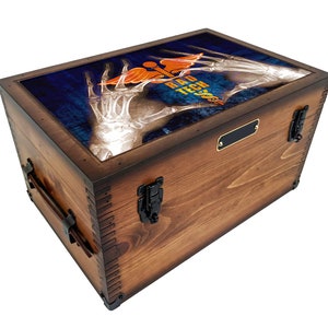 May include: A wooden storage chest with a hinged lid and metal clasps. The lid features a printed image of an x-ray of hands forming a heart shape with a medical symbol and the text "Rad Tech".