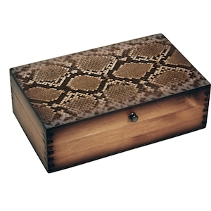 May include: A wooden box with a snakeskin pattern on the lid. The box has a brown stain and a metal latch.