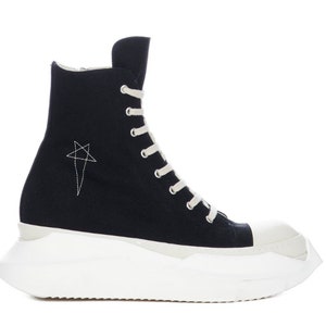 K&ouml;nnte beinhalten: Schwarze High-Top-Canvas-Sneaker mit wei&szlig;er Plateau-Sohle und einem Stern-Design an der Seite.