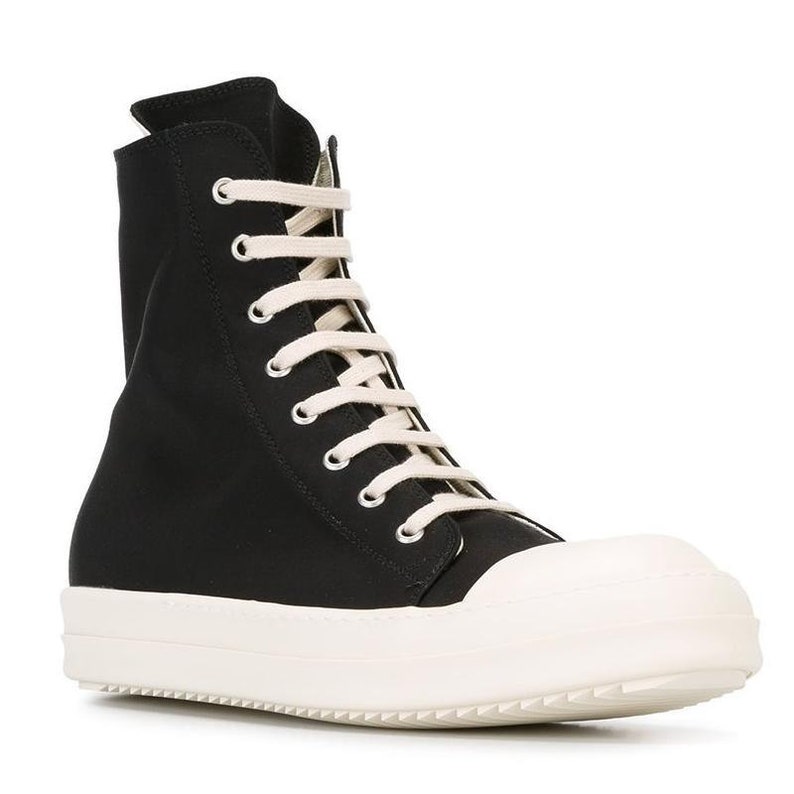 K&ouml;nnte beinhalten: Schwarze High-Top-Canvas-Sneaker mit wei&szlig;en Schn&uuml;rsenkeln und einer dicken wei&szlig;en Plateau-Sohle.