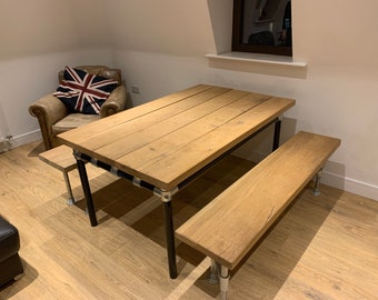 May include: A rustic wooden table with black metal legs and two matching benches. The table and benches are made of reclaimed wood and have a natural finish.