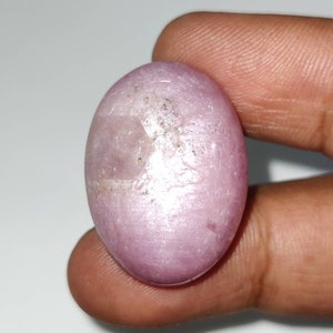 Könnte beinhalten: Ein glatter, ovaler rosa Edelstein mit einem leichten Schimmer.