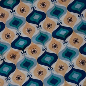 Op de afbeelding: Een herhalend patroon van blauwe, turquoise en witte druppelvormen op een perzikkleurige achtergrond. De druppelvormen zijn donkerblauw omrand en hebben een wit centrum. Het patroon doet denken aan het ontwerp van de jaren 1960 en 1970.