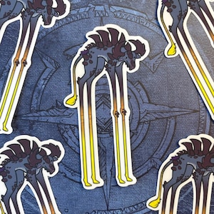 May include: Four colorful stickers featuring a stylized creature with long legs and a spiky back. The creature is depicted in a dark purple, black, and yellow color scheme. The stickers are set against a blue background with a compass design.