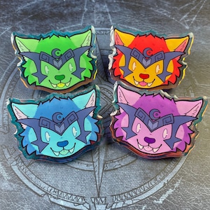 May include: Four colourful enamel pins featuring a cartoon wolf wearing a helmet. The pins are green, red, purple, and blue.