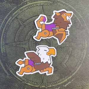 May include: Two cartoon animal stickers, a lion and an eagle, both wearing purple and brown armor. The lion is facing right and the eagle is facing left.