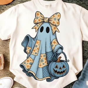 Op de afbeelding: Wit T-shirt met een cartoon spook in een blauw patchwork kostuum, bloemenstrik en een pompoenemmer. Het spook heeft zwarte ogen en houdt een blauwe pompoen vast. Een leuk Halloween-ontwerp.