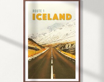 May include: Framed print featuring a scenic view of Route 1 in Iceland. The image shows a long, straight road leading towards snow-capped mountains under a pale sky. The text "ROUTE 1 ICELAND" is displayed at the top in yellow.