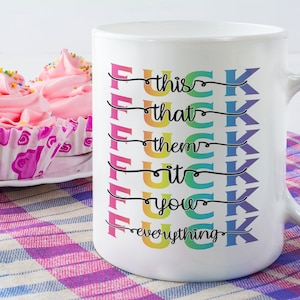 May include: White ceramic coffee mug with a rainbow design and the text "F*** this, F*** that, F*** them, F*** it, F*** you, F*** everything".