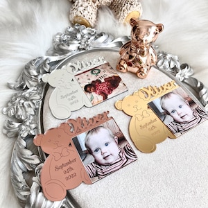 May include: Three personalized photo frames shaped like teddy bears with the name "Oliver" and the date "September 24th, 2022". The frames are silver, gold, and rose gold.