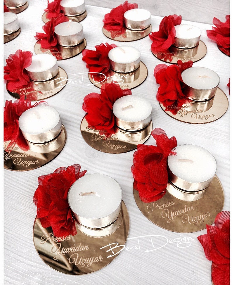 May include: Gold mirrored round candle holders with red fabric flowers and white tea light candles. Each holder has the text "Prenses Yuvadan U&ccedil;uyor" engraved on the surface.