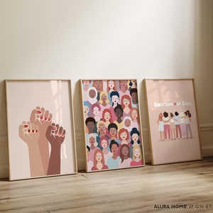 K&ouml;nnte beinhalten: Drei gerahmte Drucke mit feministischem Thema. Der linke Druck zeigt eine geballte Faust mit drei verschiedenen Hautt&ouml;nen. Der mittlere Druck zeigt eine Collage von Frauen Gesichtern mit verschiedenen Hautt&ouml;nen und Frisuren. Der rechte Druck zeigt eine Gruppe von Frauen mit verschiedenen Hautt&ouml;nen und Frisuren, die mit ihren Armen umeinander stehen. Der Text "Girls Support Girls" ist oben auf dem rechten Druck gedruckt.