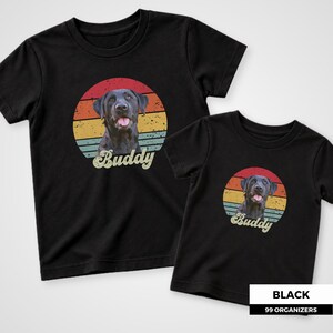 Custom dog portrait shirt featuring a favorite pet photo with a distressed 1970s-style sunset in red, orange, golden yellow, and teal behind the animal. Personalized vintage script lettering displays the pet’s name across the bottom of the design. A retro pet photo tee for dog moms, dog dads, cat owners, pet lovers, personalized birthday gifts, memorial keepsakes, and families looking for a meaningful custom shirt featuring their own pet.