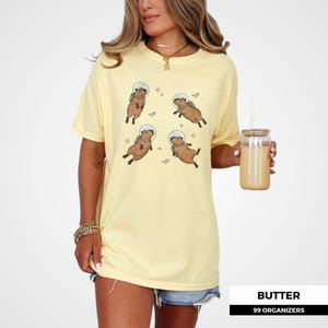 Illustration of space capybaras in various floating poses surrounded by stars. Ideal for capybara lover gifts, weirdcore aesthetic fans, and lovers of funny, vintage animal shirts. A cute and cosmic twist on meme tees and retro prints.