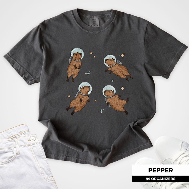 Cute capybara floating in space wearing an astronaut helmet and backpack. A quirky design for space lovers, capybara fans, and fans of kawaii and sci-fi aesthetic. Perfect funny animal gift or graphic tee for meme lovers, cottagecore fans, and rodent enthusiasts.