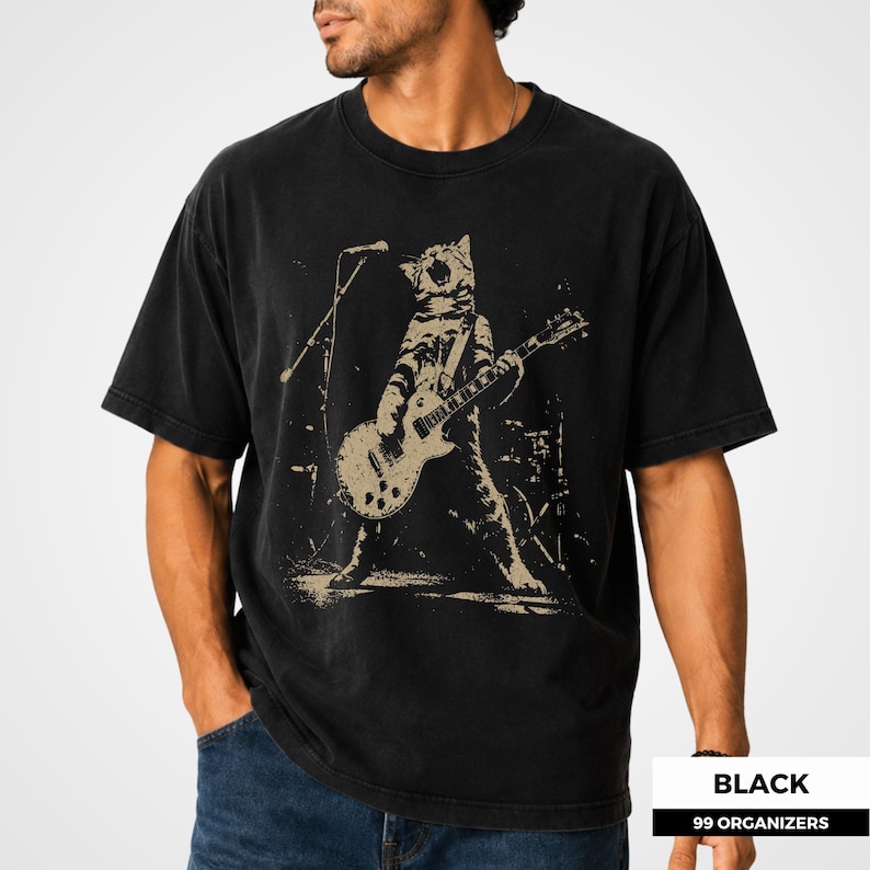 Vintage cat guitar design showcasing an energetic feline musician standing upright with a solid-body electric guitar and singing toward a stage microphone. The rough halftone texture, dramatic pose, and dark concert setting give the artwork a rebellious punk and grunge aesthetic. This cat lover graphic appeals to rock music fans, guitar players, band members, alternative style shoppers, and collectors of unusual animal art.
