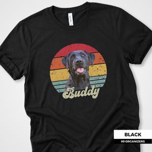 Retro custom pet shirt featuring a personalized dog or cat photo placed in front of a distressed sunset circle with warm red, orange, yellow, and muted teal stripes. The pet’s name is displayed below in oversized vintage script lettering. A unique personalized pet portrait tee for dog lovers, cat owners, pet parents, birthdays, custom pet gifts, memorial keepsakes, and anyone who wants a favorite animal photo transformed into a nostalgic graphic design.