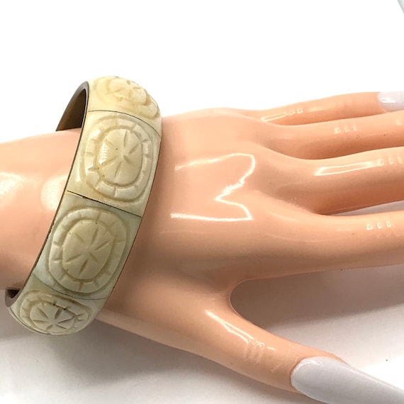 Carved cream and brass tone bracelet, bangle.