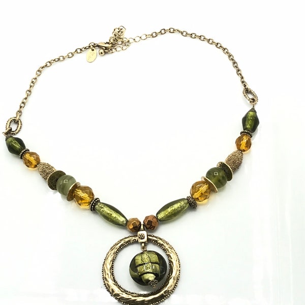Gorgeous glass beads and brass tone necklace by Lia Sophia, green and yellow beads and large round pendant.