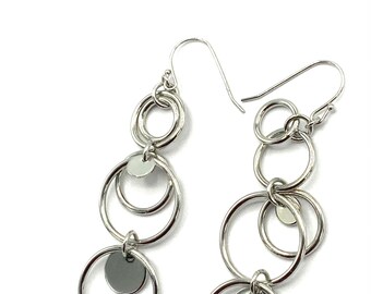 Gorgeous collectible silver tone earrings by Lia Sophia. Round, hoop, large round.