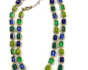 May include: A gold chain necklace with green, blue, and yellow square-shaped beads.