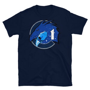 May include: A navy blue t-shirt with a distressed blue and white graphic of a dragon's head with a rocket ship in its mouth. The graphic is surrounded by a circle with the number "1" in the center.