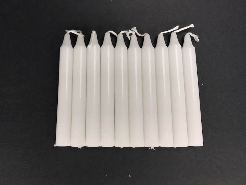 May include: A set of ten white taper candles, each approximately 6 inches long.
