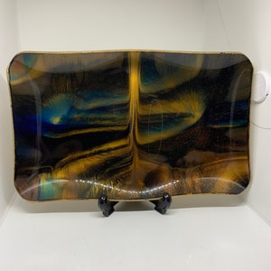 May include: A rectangular serving tray with a black, gold, and blue marbled design. The tray is made of resin and has a glossy finish.