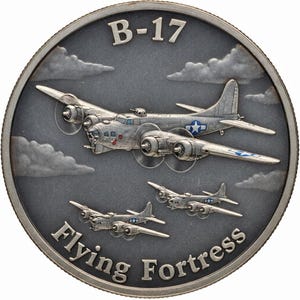 May include: A silver-colored coin featuring a detailed depiction of a B-17 Flying Fortress bomber plane in flight, with the text "B-17" at the top and "Flying Fortress" at the bottom. The coin has a detailed, textured background.