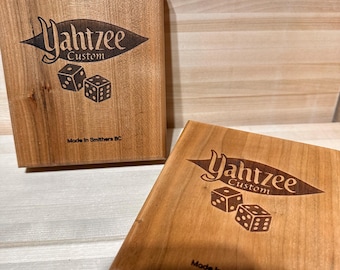 May include: Two wooden boxes with a laser-engraved design. The boxes are made of light brown wood and feature the words "Yahtzee Custom" and "Made in Smithers BC".