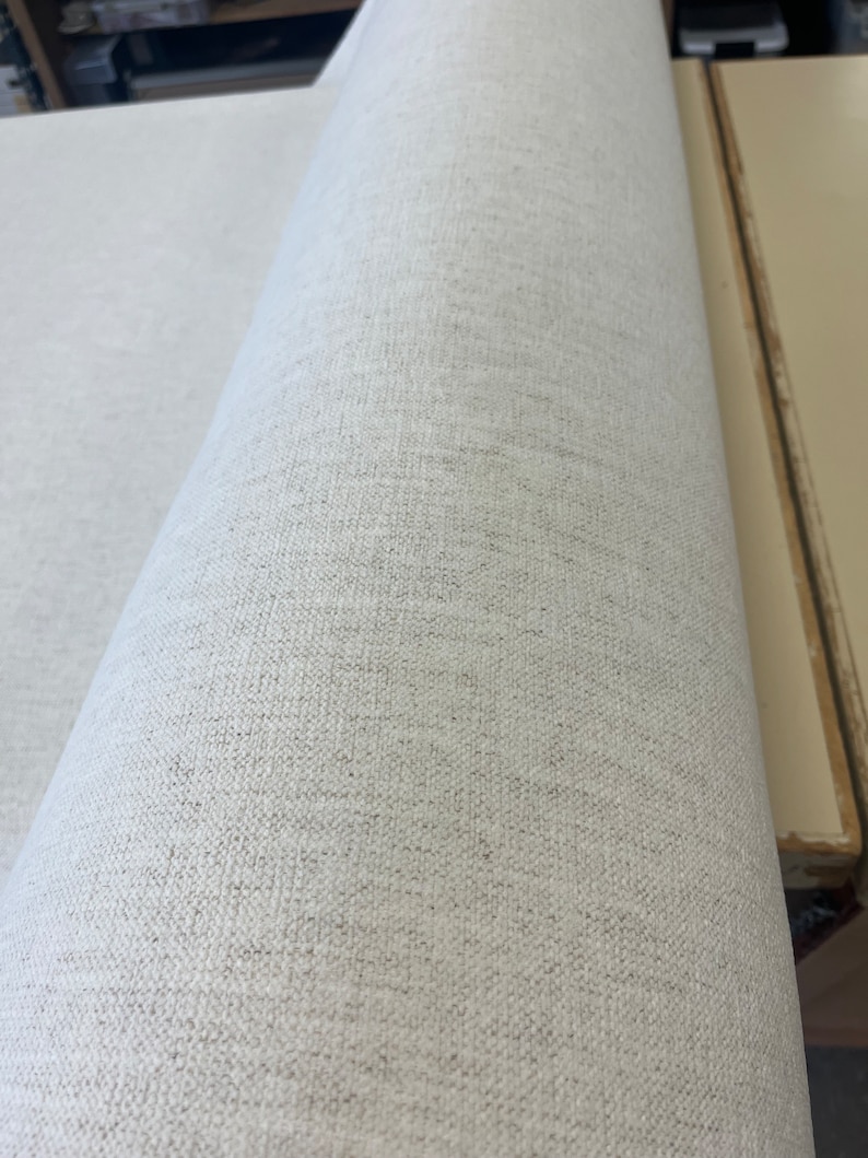 May include: Close-up of a white fabric roll with a textured surface. The fabric has a subtle woven pattern.