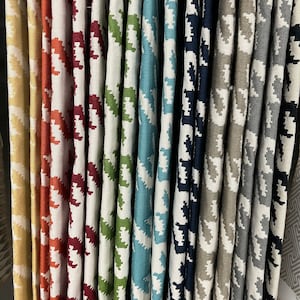 May include: A variety of fabric swatches in a houndstooth pattern. The swatches are arranged in a row and are in various colors, including yellow, orange, red, green, blue, and gray.