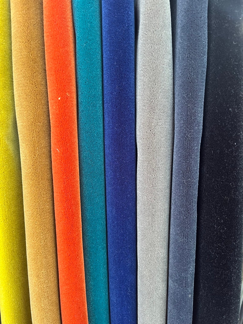 May include: A close-up of eight fabric swatches in different colors, including yellow, orange, teal, blue, gray, and black. The fabric has a soft, velvety texture.