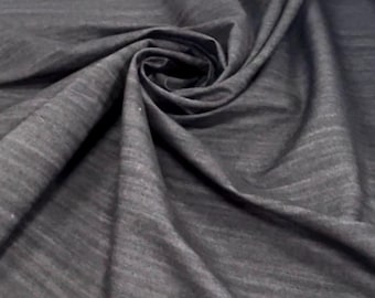 May include: Close-up of dark gray fabric with a subtle, textured pattern. The fabric is swirled and folded, creating a dynamic display of light and shadow. The material appears soft and drapes gracefully, suggesting it could be used for clothing or home decor.