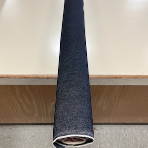 May include: A roll of dark blue denim fabric with white stitching.