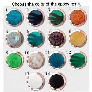Op de afbeelding: Kies de kleur van de epoxyhars. Veertien verschillende kleurstalen worden weergegeven in een raster, genummerd van 1 tot en met 14. De stalen zijn gerangschikt in een raster van vier rijen en vier kolommen. Elk staal is een kleine, ronde schijf van epoxyhars.