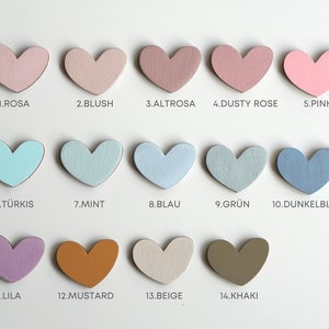 May include: A chart of 14 different paint colors displayed as heart shapes. The colors are: rosa, blush, altrosa, dusty rose, pink, t&uuml;rkis, mint, blau, gr&uuml;n, dunkelblau, lila, mustard, beige, and khaki.