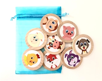 May include: A set of eight wooden circle game pieces with different animal faces on them. The pieces are in a light blue drawstring bag. The animals include a monkey, pig, sheep, cow, chicken, fox, rabbit, and dog.